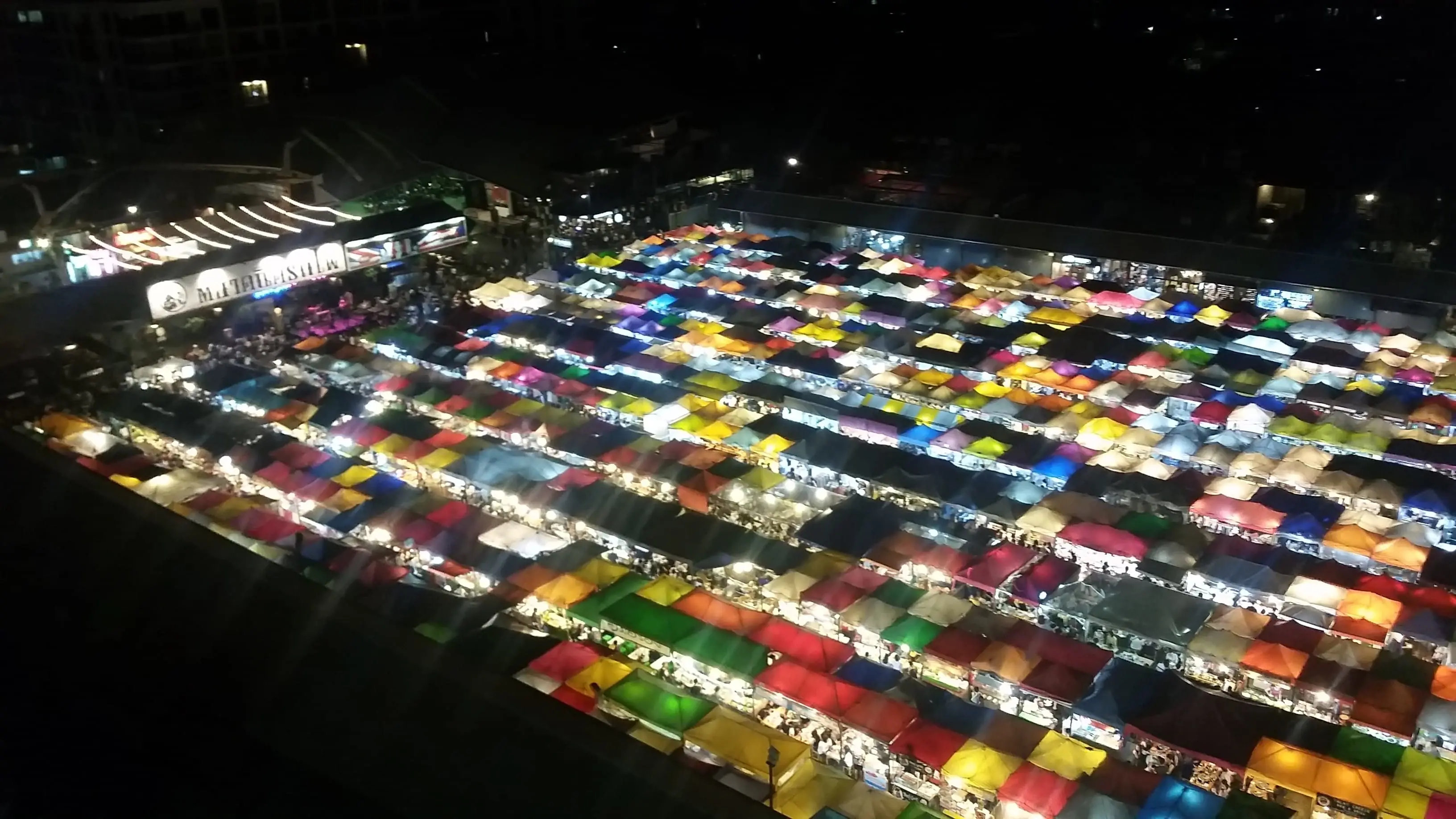 The market, each one of those stalls is packed with things, and there's a stage with a band on the far left.