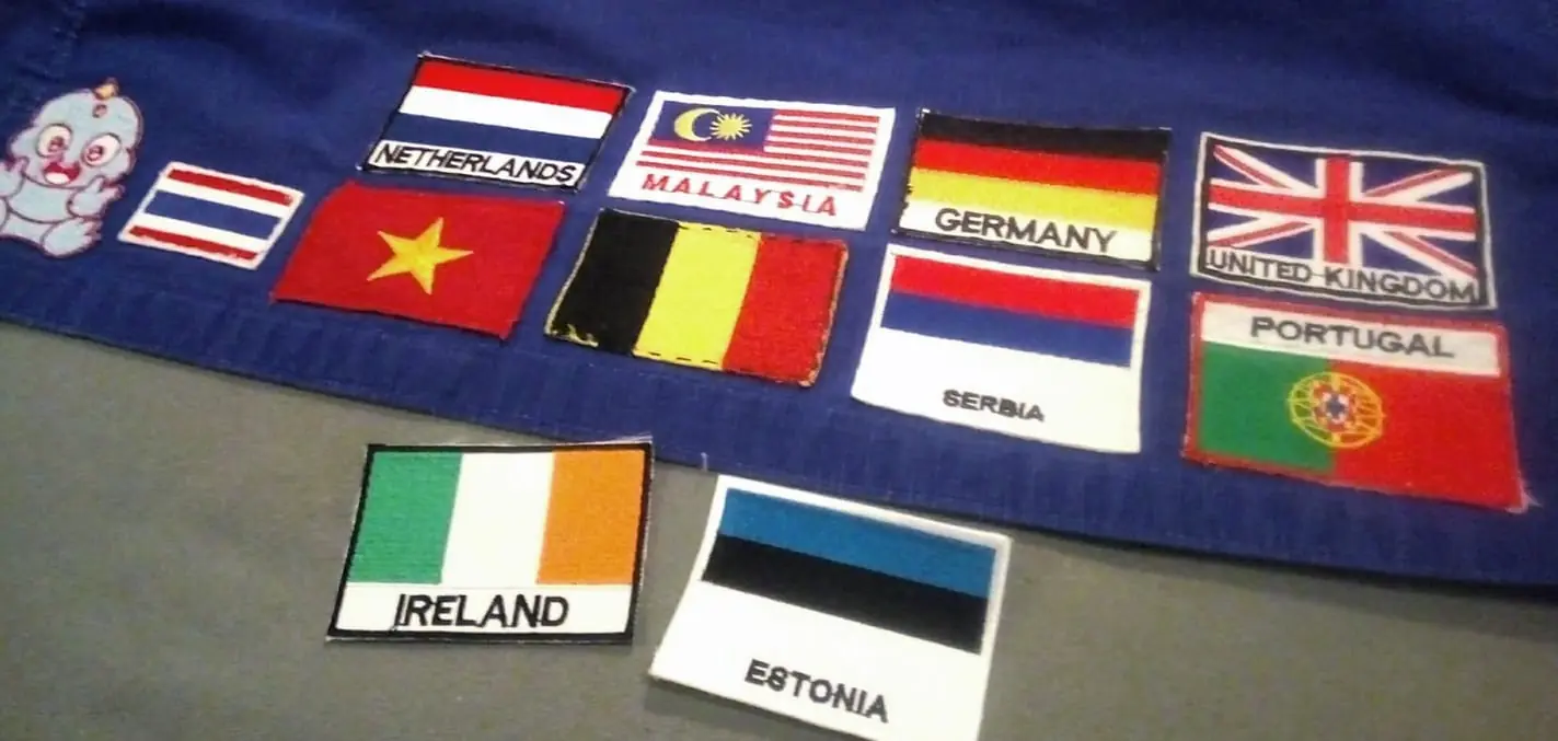 Sewing little flags onto one of my travel gis for countries in which I've trained!